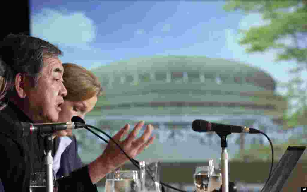 Japanese architect Kengo Kuma, left, speaks about his design of the 2020 Tokyo Olympics stadium during a press conference in Tokyo, Friday, Jan. 15, 2016.