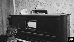 This girl did not have to anything but watch the piano roll turn on her player piano at her home in New Jersey in 1940.