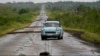 FILE - People drive along a road littered with fallen power lines after the passing of Hurricane Rafael in San Antonio de los Banos, Cuba, Nov. 7, 2024. 