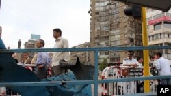 Citizens & police officers gather at the site of an explosion targeting a traffic police booth that injured two police officers, near al-Galaa bridge, in central Cairo, Egypt, Tuesday April 15, 2014.