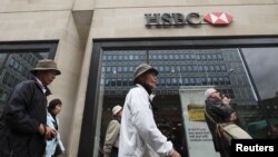 Wisatawan melewati sebuah bank HSBC di London (Foto: dok). HSBC digugat Departemen Kehakiman AS terkait usaha pencucian uang di AS. 