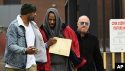 Singer R. Kelly, center, walks with his attorney, Steve Greenberg, right, and an unidentified man, left, who gave him a ride after Kelly's release from Cook County Jail, March 9, 2019, in Chicago. 