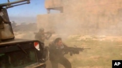 In this still image taken from video soldiers fire towards a target in Tikrit, Iraq, March 11, 2015.