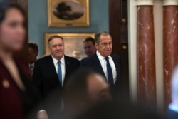 Secretary of State Mike Pompeo, left, follows Russian Foreign Minister Sergey Lavrov to a press conference, after their meeting at the State Department, Dec. 10, 2019, in Washington.