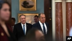 Secretary of State Mike Pompeo, left, follows Russian Foreign Minister Sergey Lavrov to a press conference, after their meeting at the State Department, Dec. 10, 2019, in Washington. 