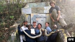 Los dos cazadores de serpientes de la India Vadivel Gopal y Masi Sadaiyan, posando con una serpiente junto a otras personas. Foto tomada durante sus ocho primeros días de trabajo en los Everglades, en Florida.