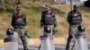 Paramilitary soldiers stand guard with riot gears at a road barricaded with shipping containers ahead of a planned rally by supporters of imprisoned former Prime Minister Imran Khan's Pakistan Tehreek-e-Insaf party, in Islamabad, Nov. 24, 2024.