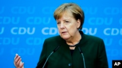 FILE - German Chancellor Angela Merkel addresses a new conference after a board meeting of her Christian Democratic Union party at the headquarters in Berlin, Nov. 27, 2017. 