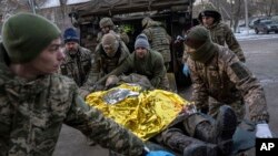 Médicos militares ucranianos trasladan a un soldado ucraniano herido desde el campo de batalla a un hospital en la región de Donetsk, en Ucrania, el lunes 9 de enero de 2023. El soldado no sobrevivió.