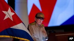 El expresidente cubano Raúl Castro mira la bandera cubana durante su discurso en el evento de celebración del 65 aniversario del triunfo de la revolución en Santiago, Cuba, el lunes 1 de enero de 2024.