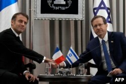 Presiden Prancis Emmanuel Macron (kiri) berjabat tangan dengan Presiden Israel Isaac Herzog saat pertemuan di Yerusalem, pada 24 Oktober 2023. (Foto: AFP)