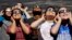 Fourth graders at Clardy Elementary School in Kansas City, Missouri, practice the proper use of their eclipse glasses in anticipation of Monday's solar eclipse, Aug. 18, 2017.