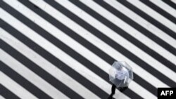 A pedestrian crosses a street on a rainy day in Tokyo.