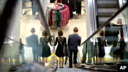 A couple descend an escalator while shopping at an H& M store, in Atlanta. U.S.