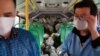 Des livreurs d'une épicerie à l'intérieur de leur bus à Wuhan, l'épicentre de l'épidémie du nouveau coronavirus, dans la province du Hubei en Chine, le 5 mars 2020.