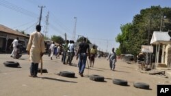 Vigilantes barricade a road after twin blasts exploded at a crowded market in Maiduguri, Nigeria, Dec. 1, 2014.