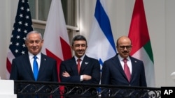 Israeli Prime Minister Benjamin Netanyahu, left, United Arab Emirates Foreign Minister Abdullah bin Zayed al-Nahyan, and Bahrain Foreign Minister Khalid bin Ahmed Al Khalifa stand on the Blue Room Balcony during the Abraham Accords signing ceremony on the