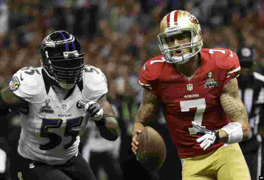 Pemain lini belakang San Francisco 49ers Colin Kaepernick (7) membawa bola melewati pemain Baltimore Ravens Terrell Suggs (55) dalam final NFL Super Bowl XLVII, Minggu (3/2) di New Orleans. 