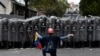 资料照片：在委内瑞拉首都加拉加斯，一名反马杜罗政权的示威者在一队防暴警察前下跪 （2020年3月10日）