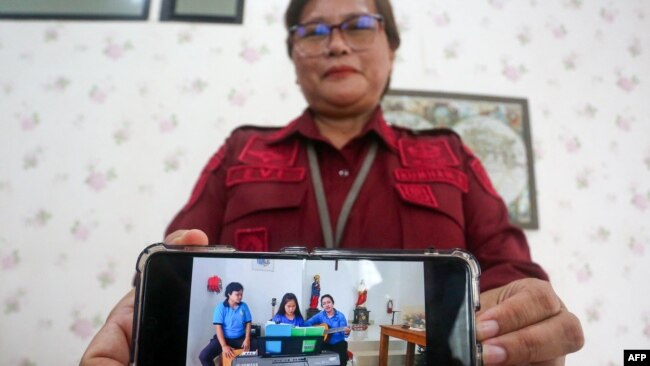 Kepala Lapas Perempuan Kelas IIB Yogyakarta, Evi Loliancy, memperlihatkan foto terbaru terpidana mati Mary Jane Veloso sedang bermain keyboard menjelang perayaan natal, di Wonosari, Yogyakarta, Kamis, 21 November 2024. (Foto: Devi Rahman/AFP)