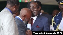 FILE: An unidentified man who was in jail with Zimbabwean President Robert Mugabe during the liberation struggle, cries, as he greets him, during celebrations to mark his 92nd Birthday celebrations in Masvingo about 300 kilometres south of Harare, Saturday, Feb, 27, 2016. (AP Photo/Tsvangirayi Mukwazhi)