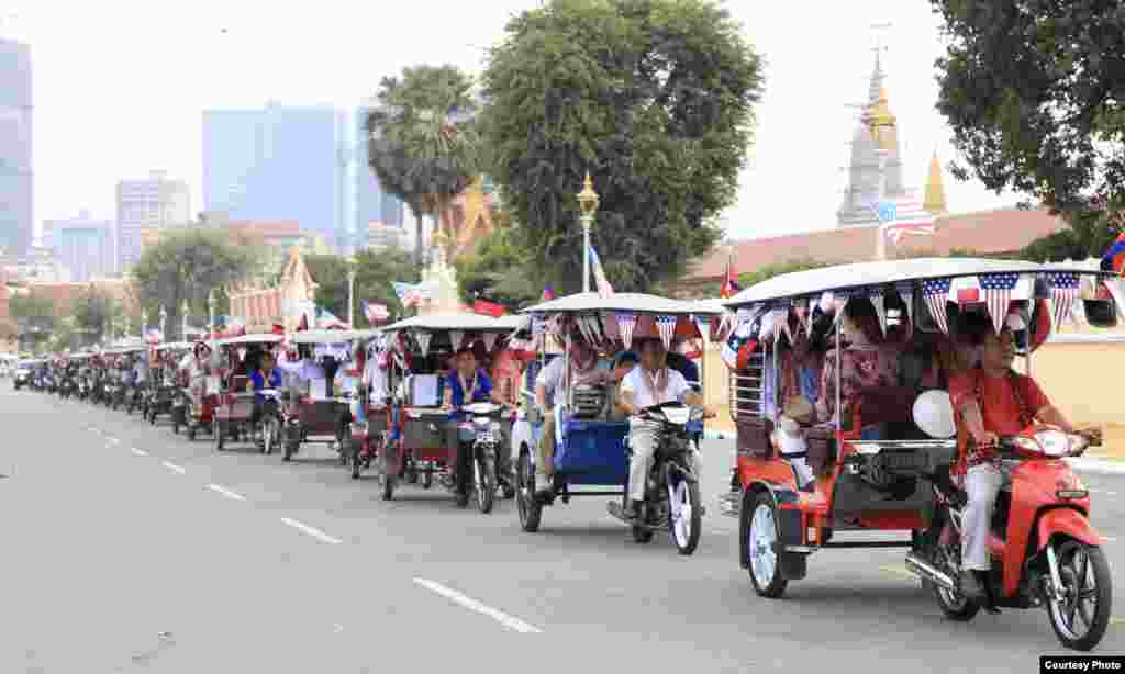 U.S. embassy employees sit in tuk-tuks, decorated with American flags, and kick-off activities marking 70 years of Cambodia-US relations in a parade along the streets in Phnom Penh, 2020. (Photo courtesy of U.S. Embassy in Cambodia) &nbsp;