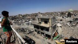 An Iraqi looks at the ruins of Grand al-Nuri Mosque and al-Hadba minaret in the destroyed Old City of Mosul, Iraq, Aug. 5, 2017. 