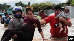امدادگران روز پنج‌شنبه ۱۵ آبان ۱۳۹۹ در هندوراس یک زن باردار را از یک منطقه سیل‌زده بیرون می‌برند. (عکس از اسوشیتدپرس) 