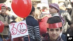 A young boy holds up a sign that reads, "Hama 1982," during a protest against Syria's President Bashar al-Assad after Friday prayers in Idlib February 3, 2012.