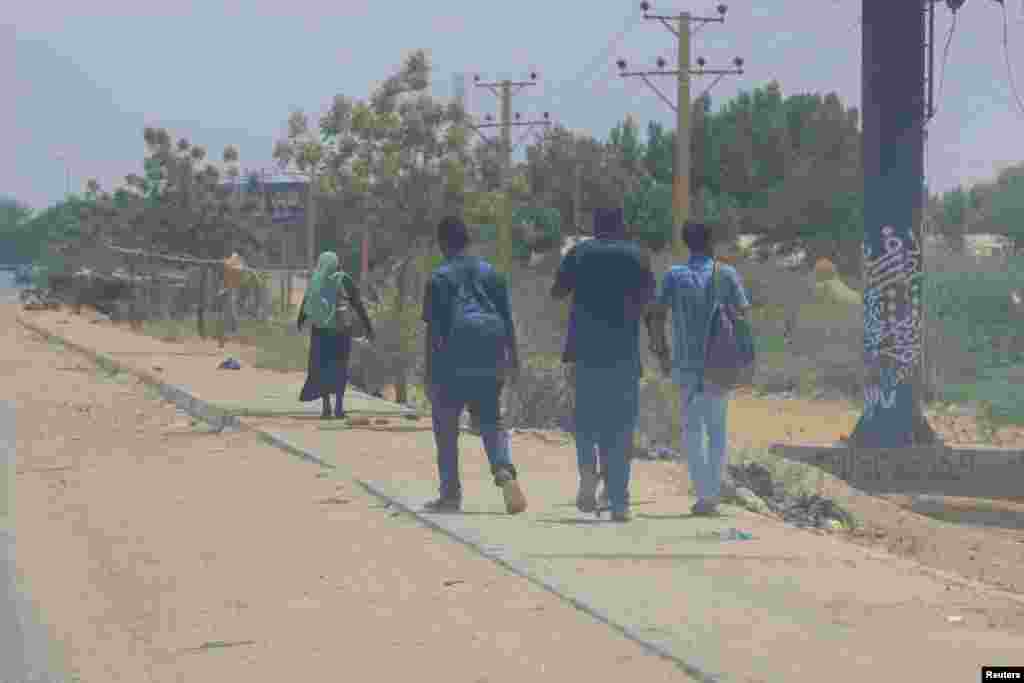 People walk near the Halfaya Bridge during clashes between the Paramilitary Rapid Support Forces and the army as seen from Khartoum North, Sudan April 15, 2023. (Reuters)