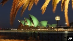 Tourists take pictures in this long exposure photograph as the Sydney Opera House is lit with green lights during St Patrick's Day celebrations in central Sydney, March 17, 2010.