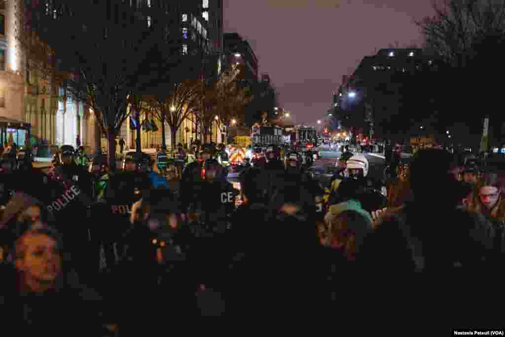 Sur la place Franklin, des militants anti-Trump se tiennent devant la police, à Washington DC, le 20 janvier 2017. (VOA/Nastasia Peteuil)