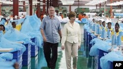 George W. Bush da Laura Bush suke ziyarar kamfanin A to Z textile mills, wadda ke sarrafa magungunan yaki da cutar zazzabin cizon sauro.