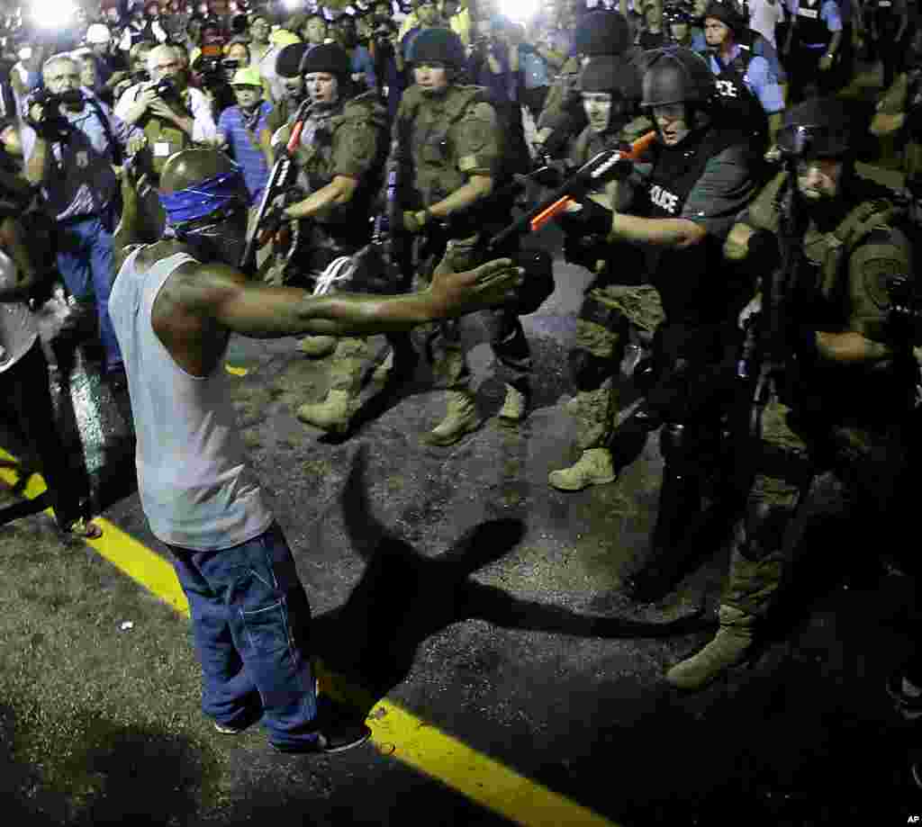 Polisi menahan seorang pria saat membubarkan para pengunjuk rasa di Ferguson, Missouri (20/8). (AP Photo/Charlie Riedel)