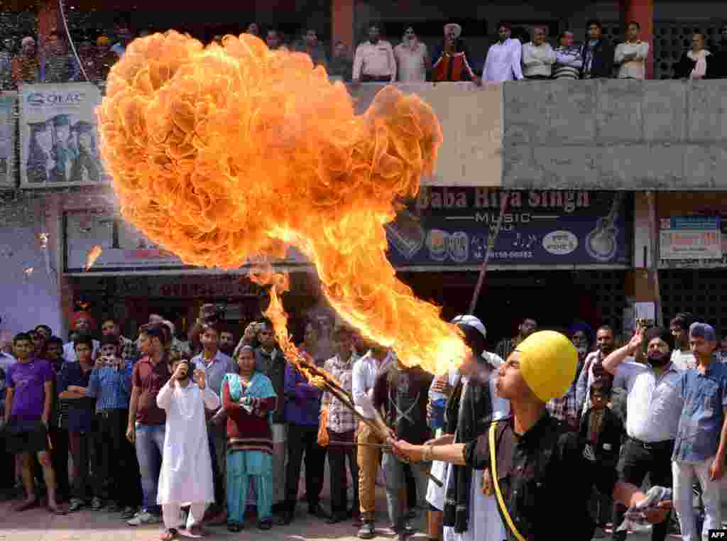 Indian Sikh youths perform fire-breathing and Gatka martial arts skills before the start of a political campaign event in Amritsar.