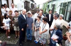 En este 23 de agosto de 2011, el vicepresidente Joe Biden, en el centro a la izquierda con un traje oscuro, tiene un momento de luz con los sobrevivientes del terremoto y tsunami del 11 de marzo durante su visita a Natori.