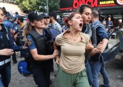 A protester is detained by police during a demonstration against the Turkish government's removal from office of three pro-Kurdish mayors on Aug. 19, 2019, in Ankara.