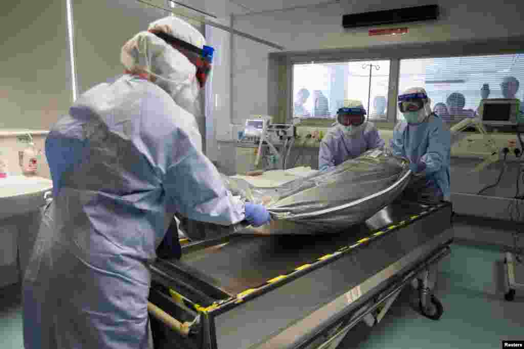 Medical personnel, wearing protective gear, take part in a drill with a dummy to demonstrate the procedures of transporting an Ebola victim, in Hong Kong, Sept. 2, 2014.