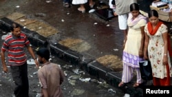 FILE - Two female sex workers stand on a roadside pavement for soliciting customers in a red light area in Mumbai July 28, 2007. An exclusive magazine for prostitutes is offering a snapshot of life in some of India's biggest brothels, reporting the murky world of pimps and violent customers and showcasing the dreams and talents of sex workers. 