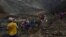 Rescuers recover bodies near the landslide area in the jade mining site in Hpakant in Kachin state on July 2, 2020. - The battered bodies of more than 120 jade miners were pulled from a sea of mud after a landslide in northern Myanmar on July 2 after one 