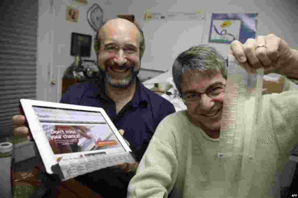 Steven Isaac, left, CEO of TouchFire and Brad Melmon, right, director of product development, pose for a photo, Thursday, Dec. 15, 2011, in Melmon's Seattle design studio. Their first product, a silicone overlay that goes on top of the virtual keyboard of