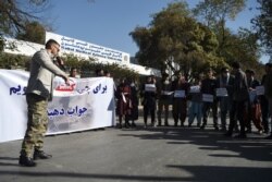Students and civil society activists hold banners in protest as they shout slogans, a day after gunmen stormed Kabul university in Kabul on Nov. 3, 2020.