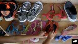 A former cybersex victim arranges a shoe rack at a shelter for sexual exploitation survivors in Manila, Philippines, April 25, 2017.