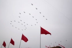 Helicopters fly over Chinese flags at Tiananmen Square in the formation of '100' during a ceremony to mark the 100th anniversary of the founding of the ruling Chinese Communist Party at Tiananmen Gate in Beijing, July 1, 2021.
