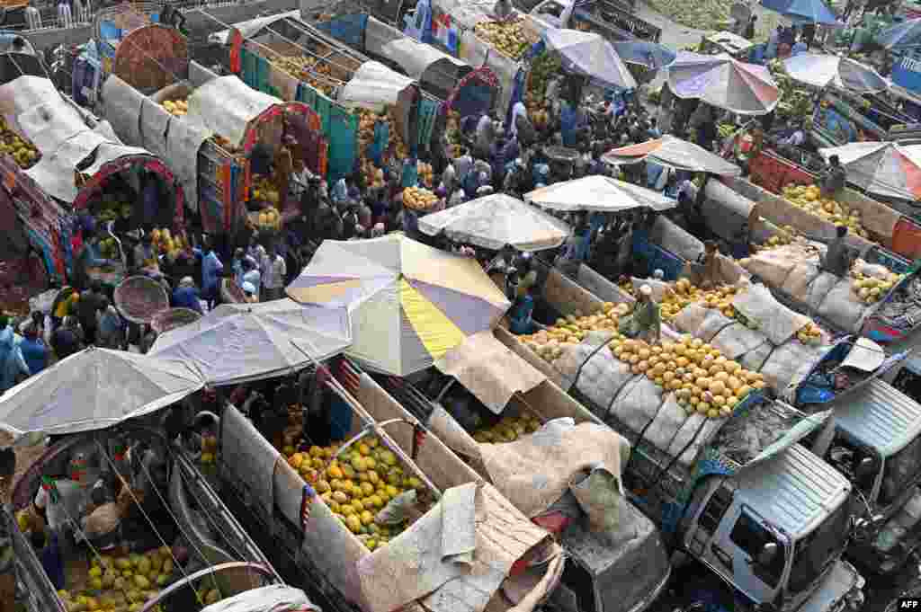 Para pedagang dan pelanggan tampak memenuhi pasar buah grosir di kota Lahore, Pakistan. (AFP)&nbsp;