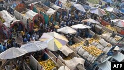 Traders and customers crowd at a wholesale fruit market in Lahore, Pakistan.