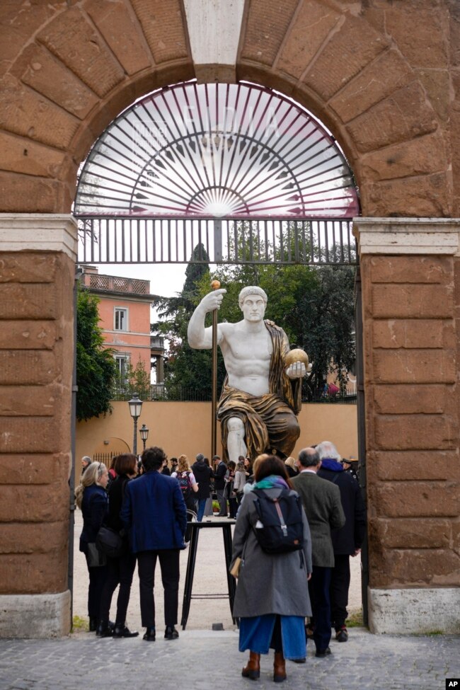 Visitors admire a massive, 13-meter replica of the statue of Roman Emperor Constantine in Rome, Tuesday, Feb. 6, 2024. . (AP Photo/Andrew Medichini)