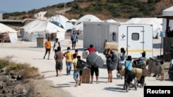 Refugees and migrants from the destroyed Moria camp enter a new temporary camp on the island of Lesbos, Greece, Sept. 20, 2020. 