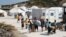 Refugees and migrants from the destroyed Moria camp enter a new temporary camp on the island of Lesbos, Greece, Sept. 20, 2020. 