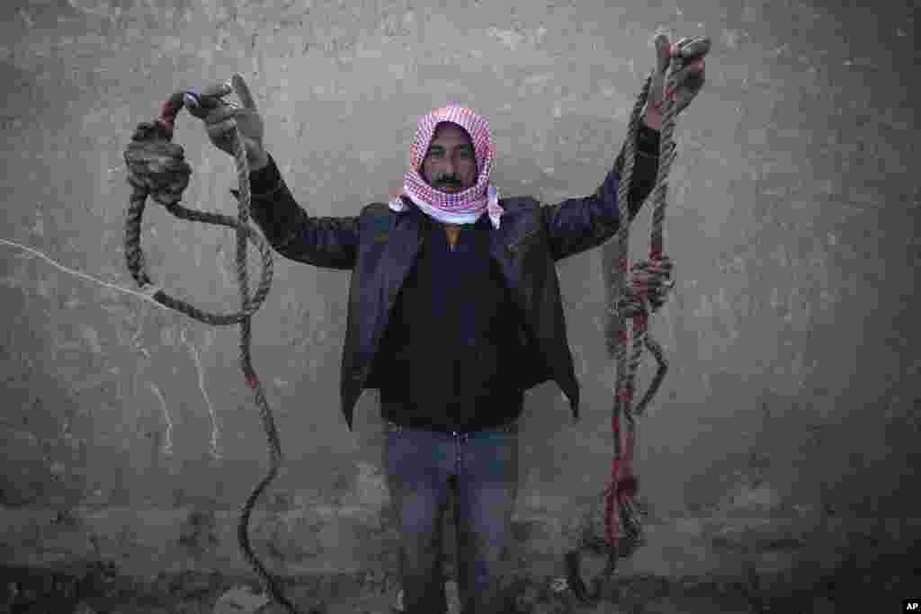 A man shows two ropes tied in the shape of nooses, found in the infamous Saydnaya military prison, just north of Damascus, Syria, Dec. 9, 2024. 